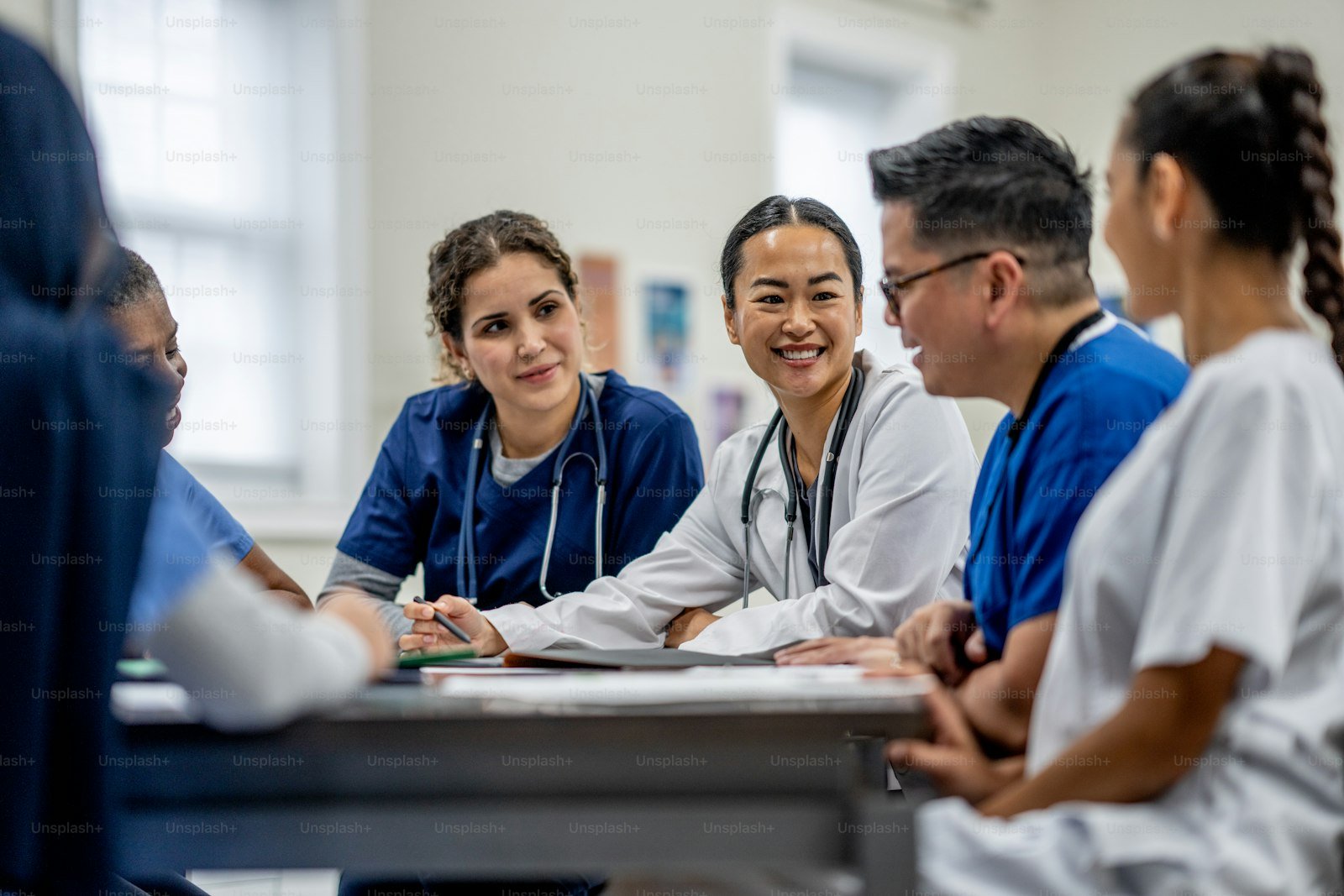 Small team of medical professionals discussing implementation plans around a meeting table